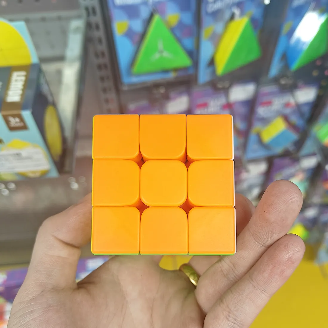 Orange side of the stickerless 3×3 speed cube, held in a hand