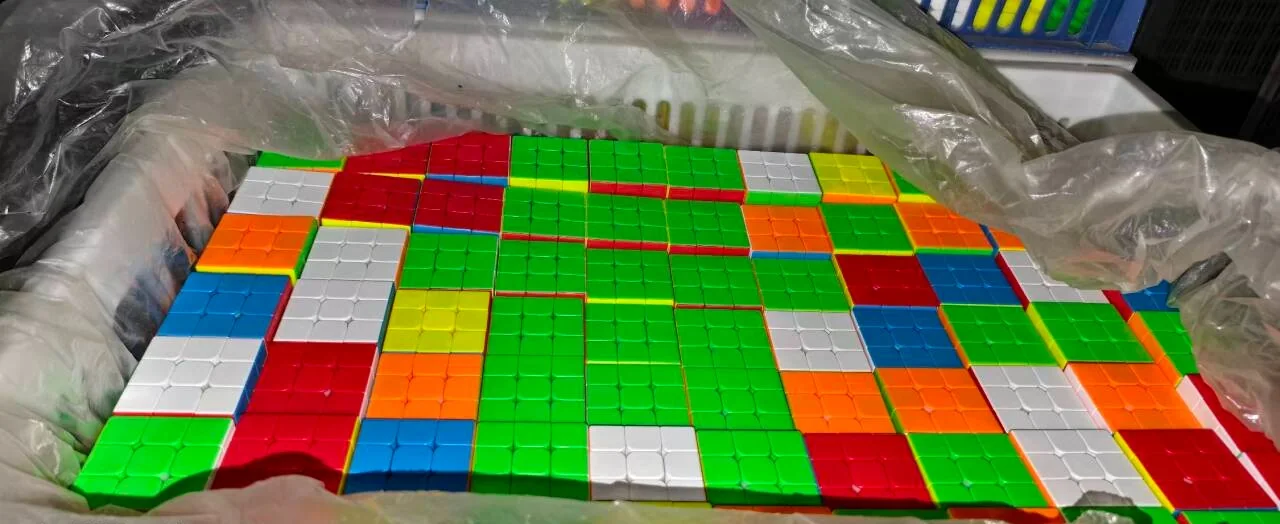 Loose stickerless cubes in a lined crate at the factory